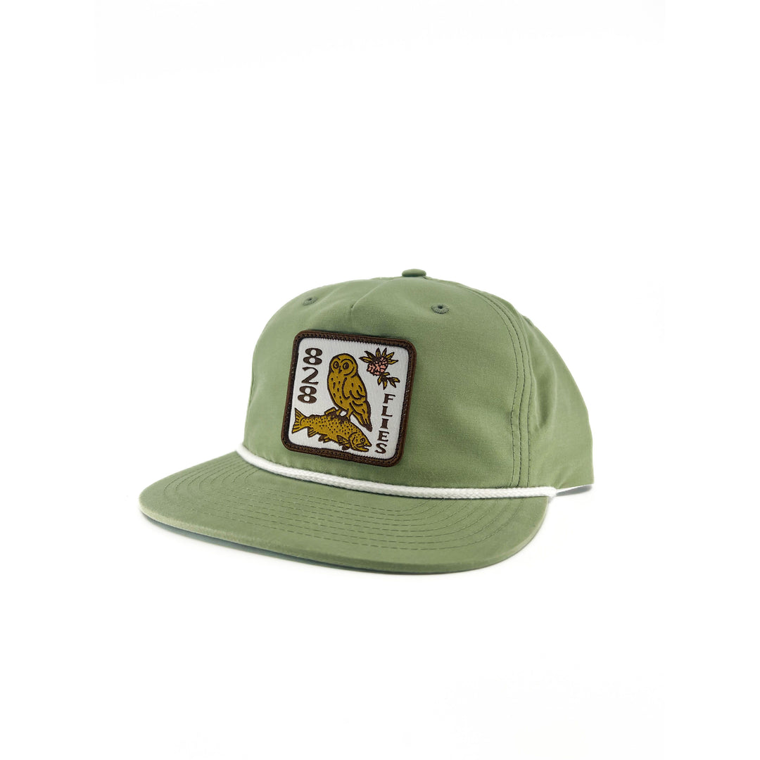 Sage green Richardson flat-brim hat with white rope trim and embroidered owl fish patch