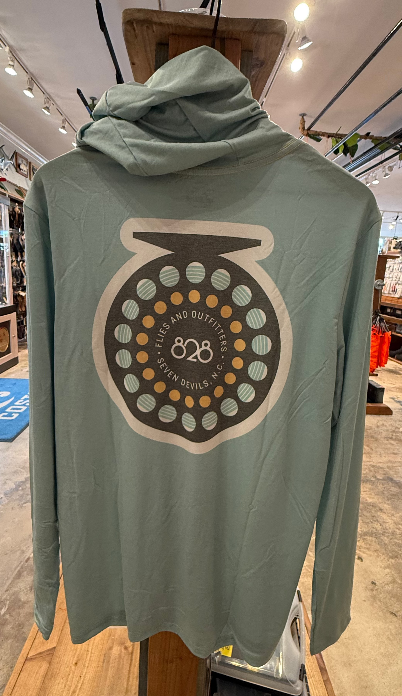Back view of 828Flies Technical Fishing Hoody featuring large reel graphic with '828' text in sage green