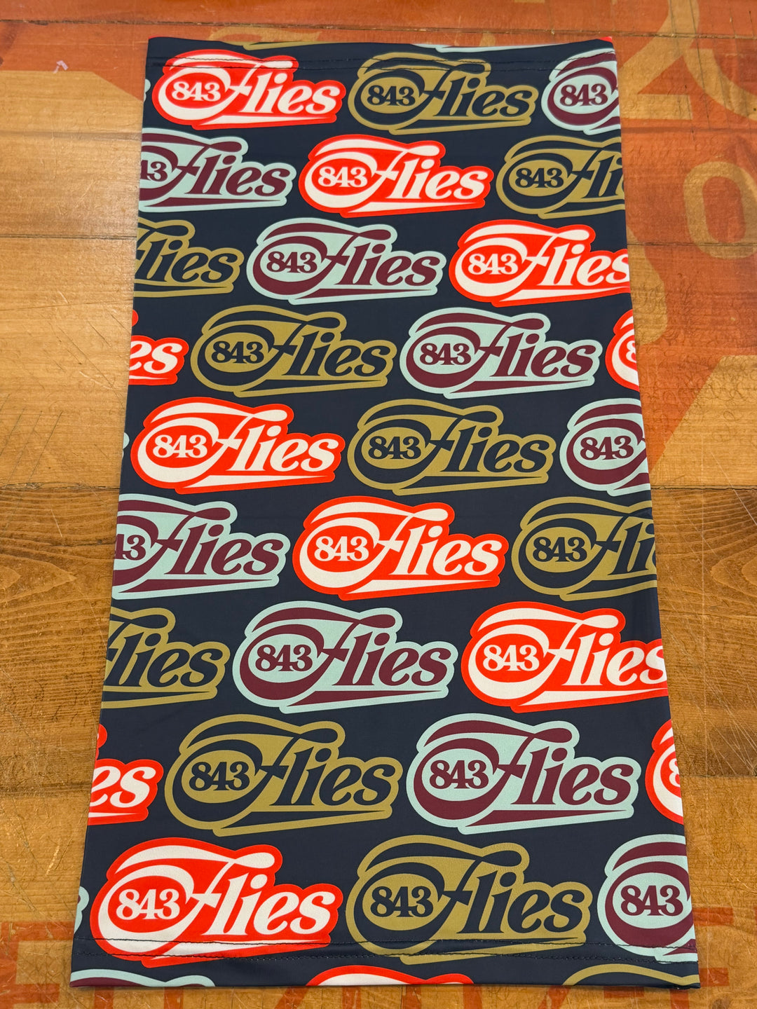 Heritage Buff sun mask with repeating 843 Flies logo pattern in red, gold, and maroon