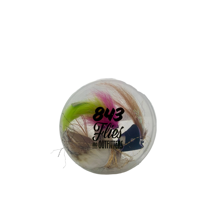 Clear fly puck filled with colorful artificial fishing flies