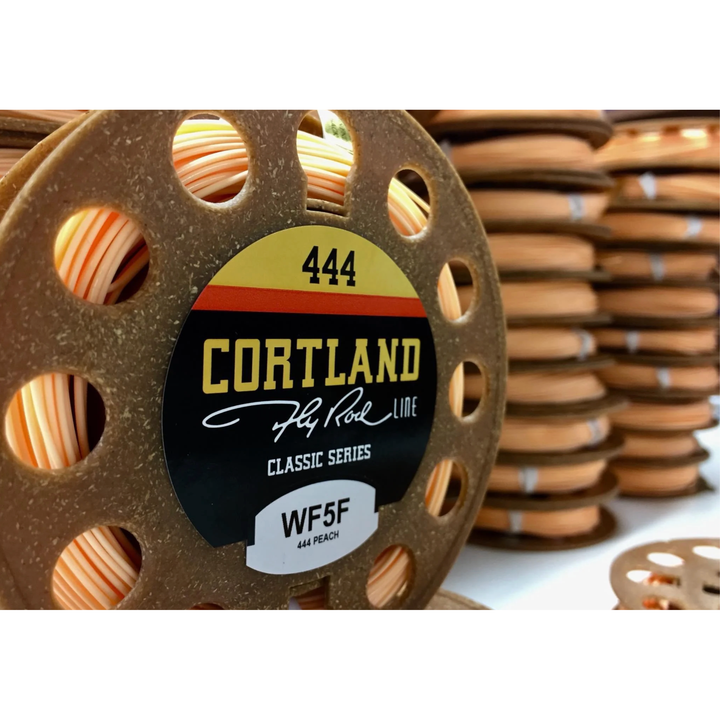 Close-up of Cortland 444 Peach WF5F fly line spool on brown speckled reel