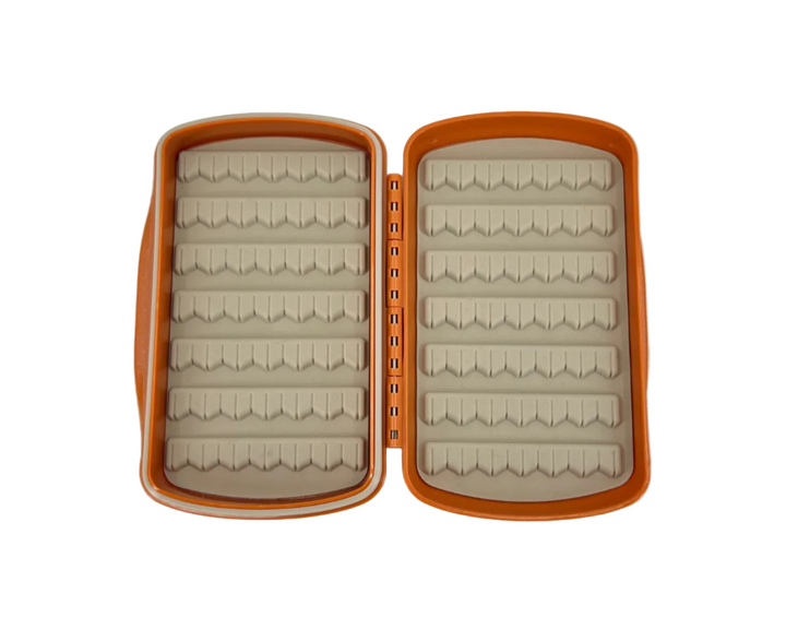 Open Fishpond Pescador fly box revealing beige foam inserts with V-shaped slots for flies