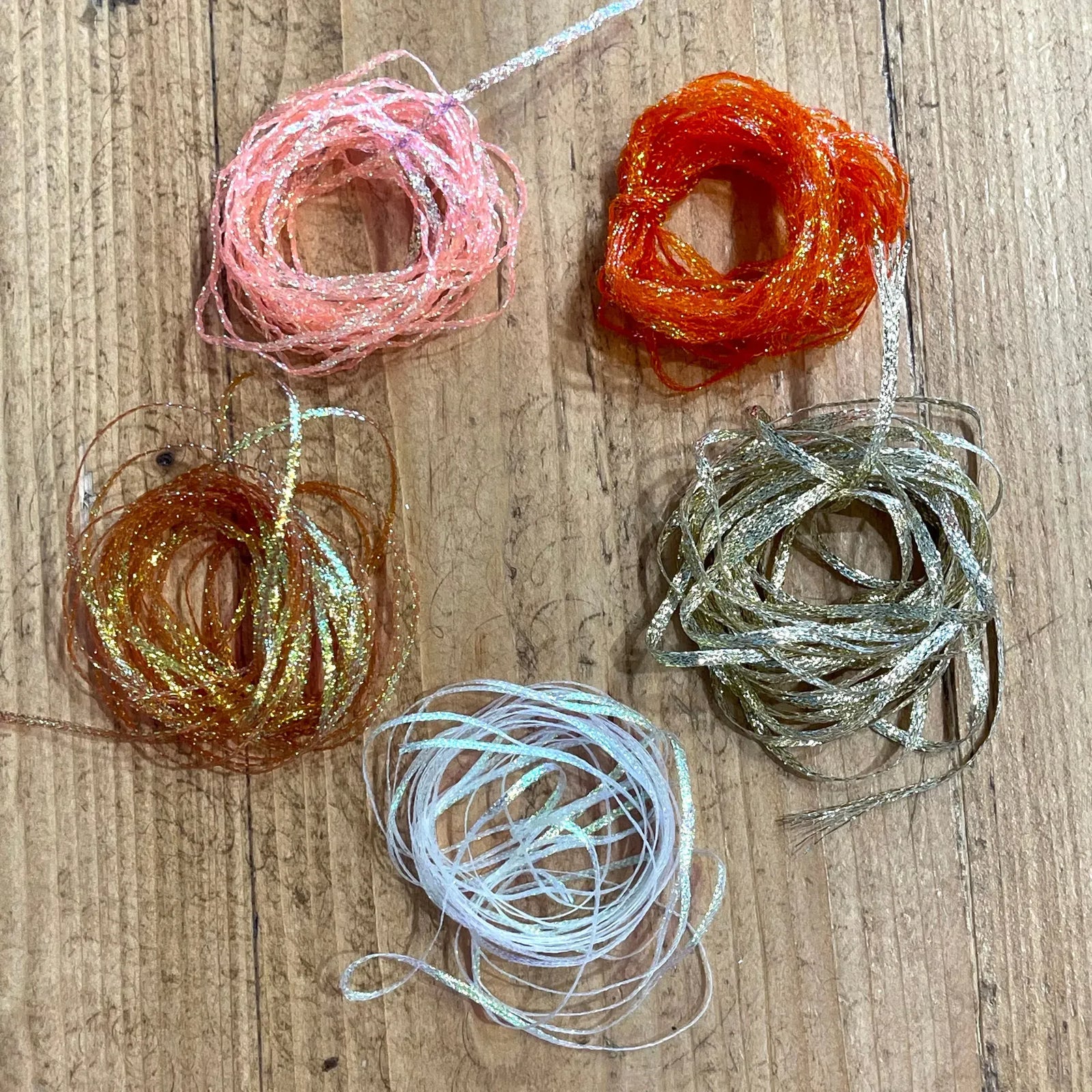 Assorted Hareline flat diamond braid colors including pink, orange, and blue flash