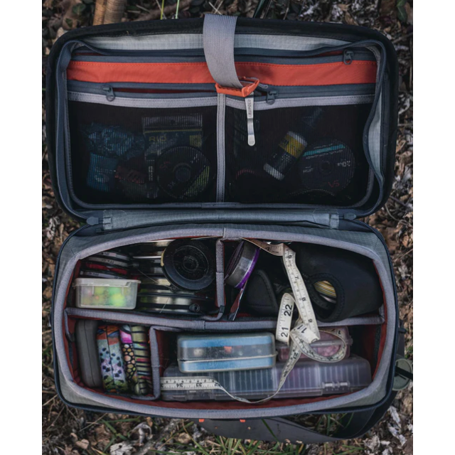 Simms Boat Bag interior with customizable dividers holding fishing reels and tackle
