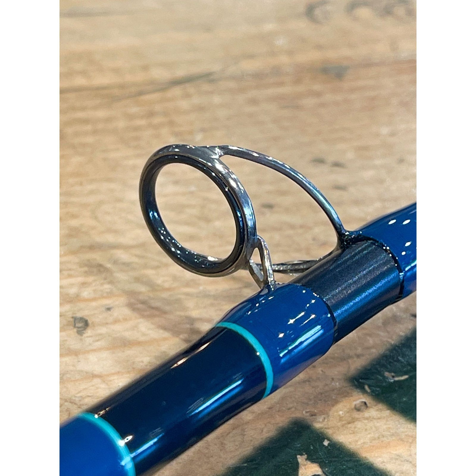 Close-up of chrome guide assembly on glossy blue Thomas & Thomas Sextant fly rod