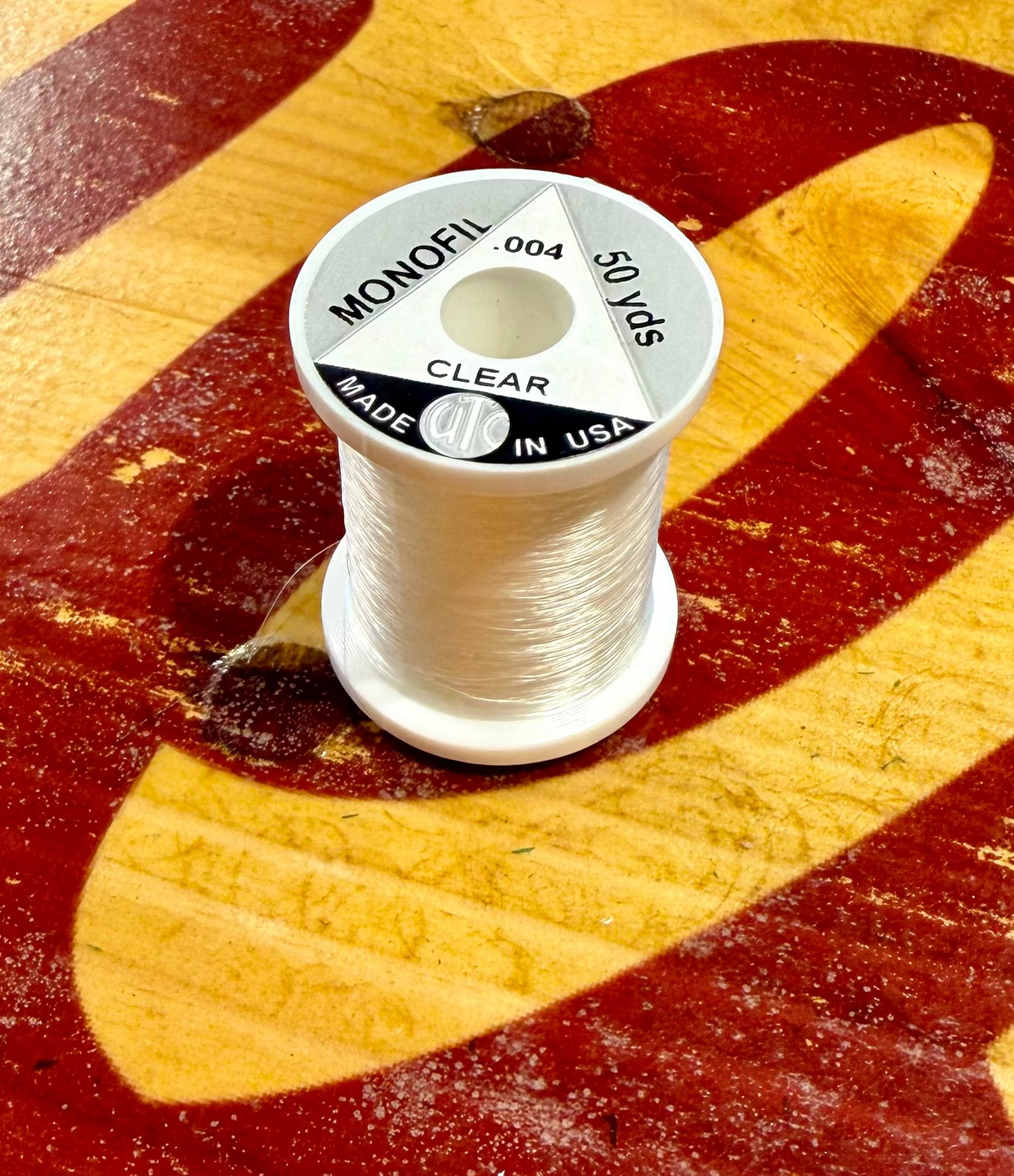 Close-up of Wapsi UTC .004 clear monofilament thread on wood