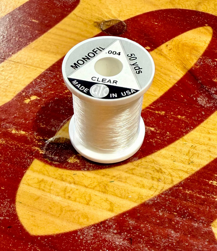 Close-up of Wapsi UTC .004 clear monofilament thread on wood