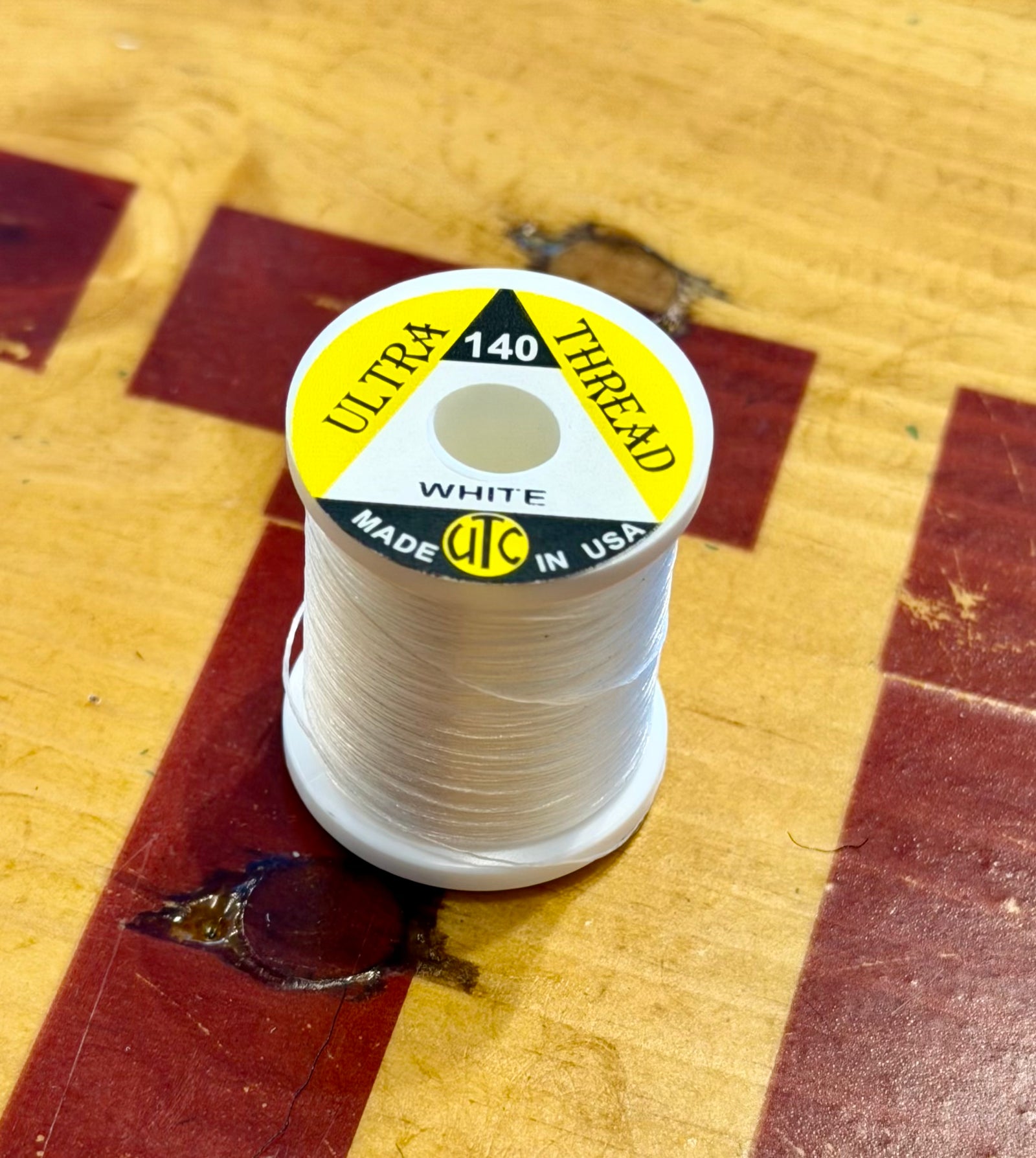 White UTC Ultra 140 thread spool for fly tying