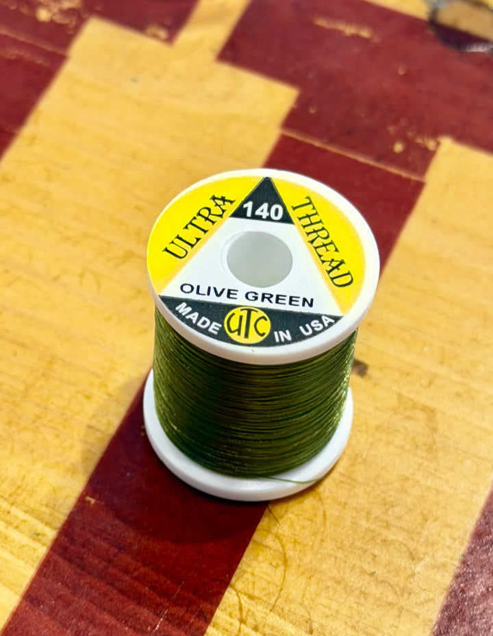 Olive Green Wapsi Ultra 140 thread on wooden surface