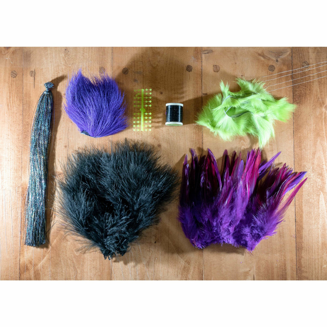 Flat lay of fly tying materials including hooks and feathers