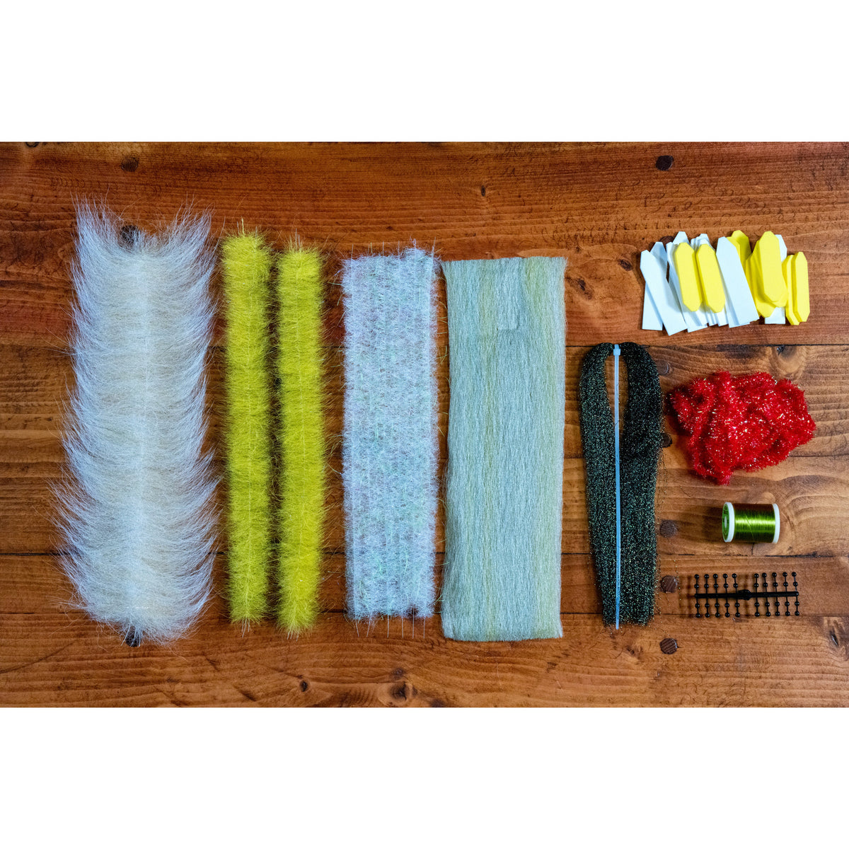 Casa Clorinda Cruncher fly tying kit materials flat lay with brushes, flash, chenille, and olive thread