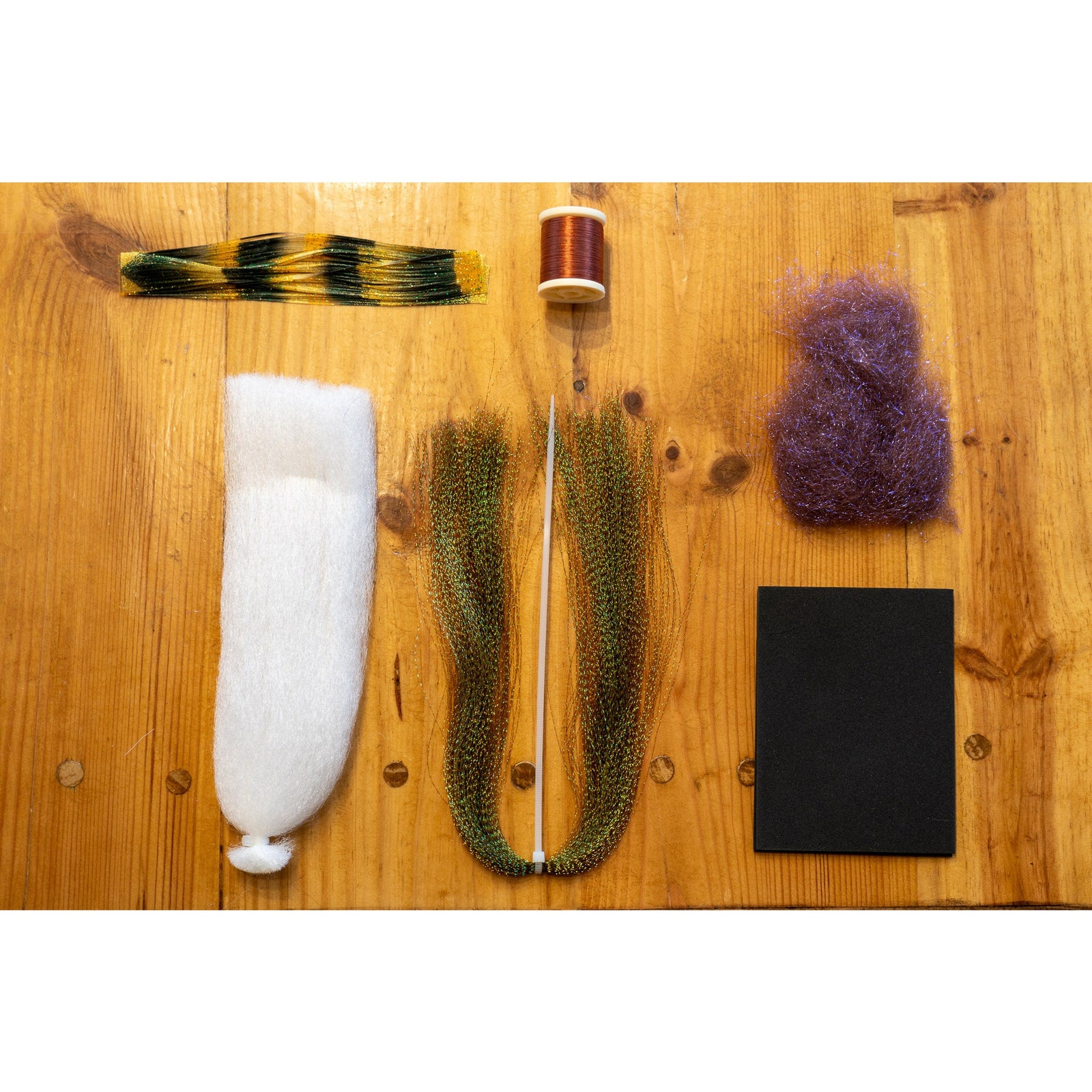 Chubby Chernobyl DIY fly tying kit materials including black foam, brown thread, and iridescent fibers