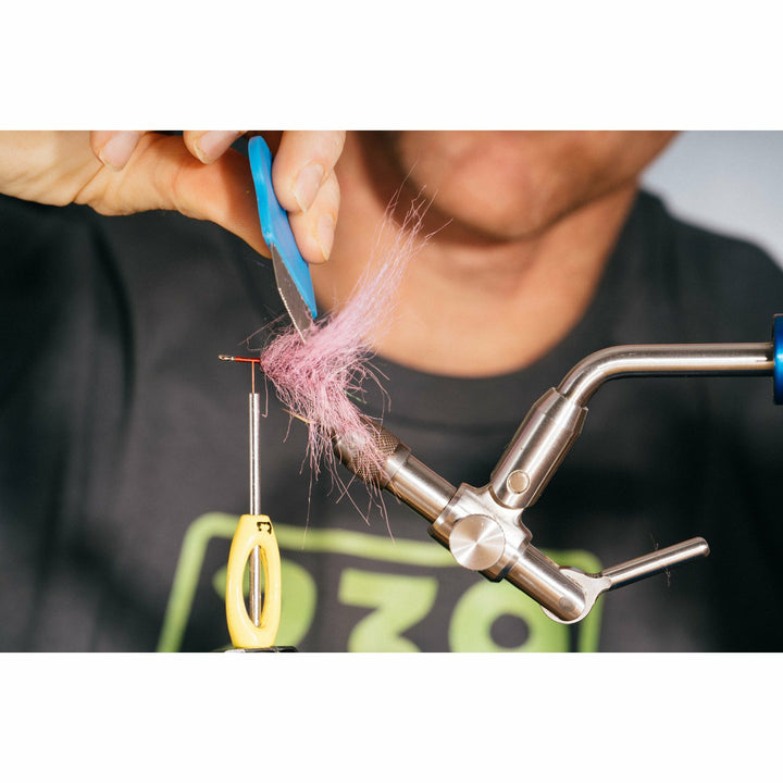Shaping hot pink synthetic fur tail on fishing fly