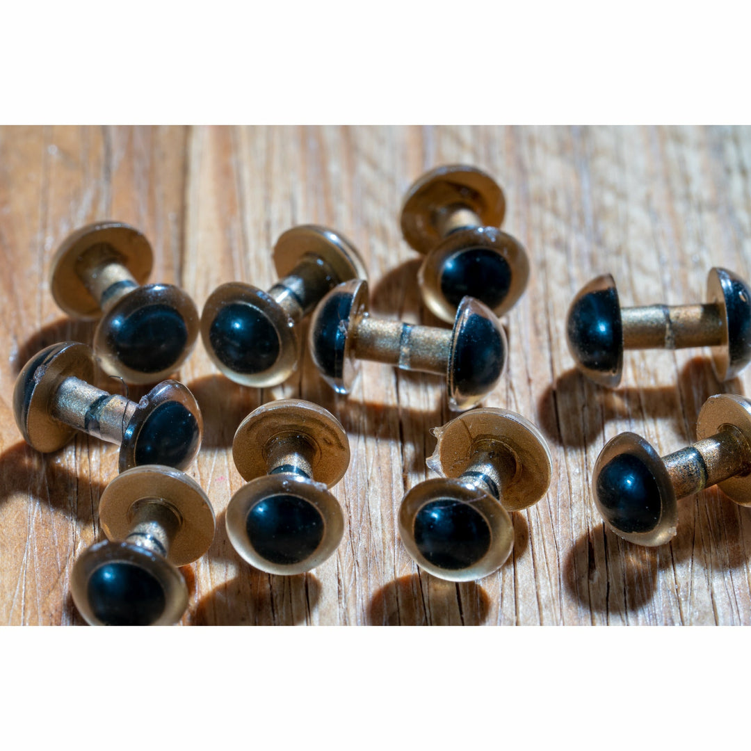 Golden figure-8 fly tying eyes with black resin lenses and gold shanks