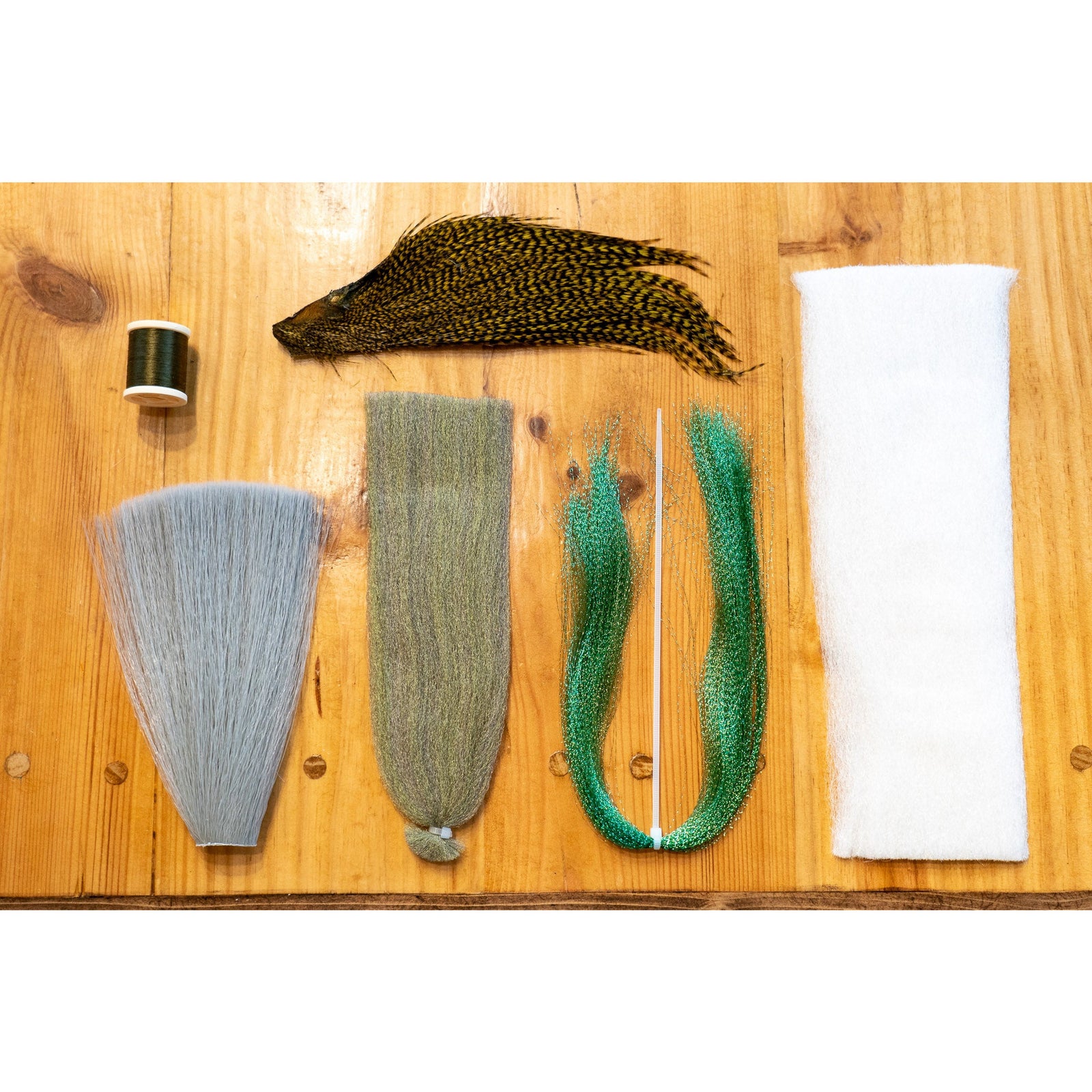 Fly tying kit materials including bucktail, thread, and fibers