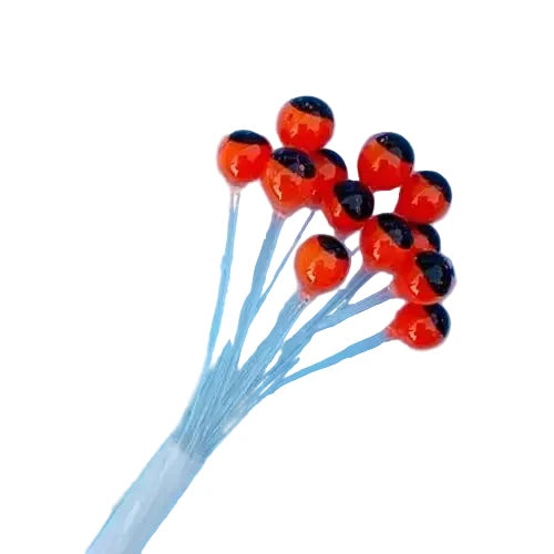 Bright orange-red plastic fly eyes with glossy black pupils on stems