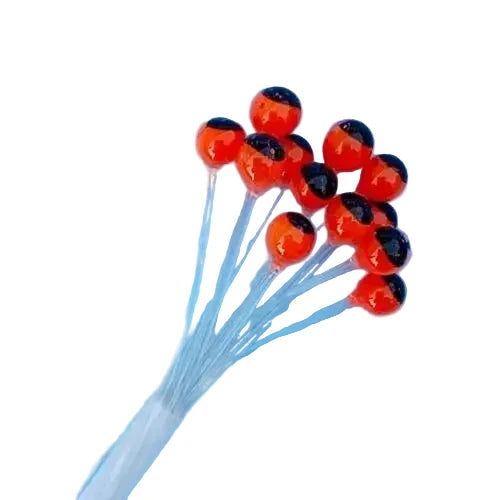 Orange-red round fly tying eyes with black pupils on translucent stems