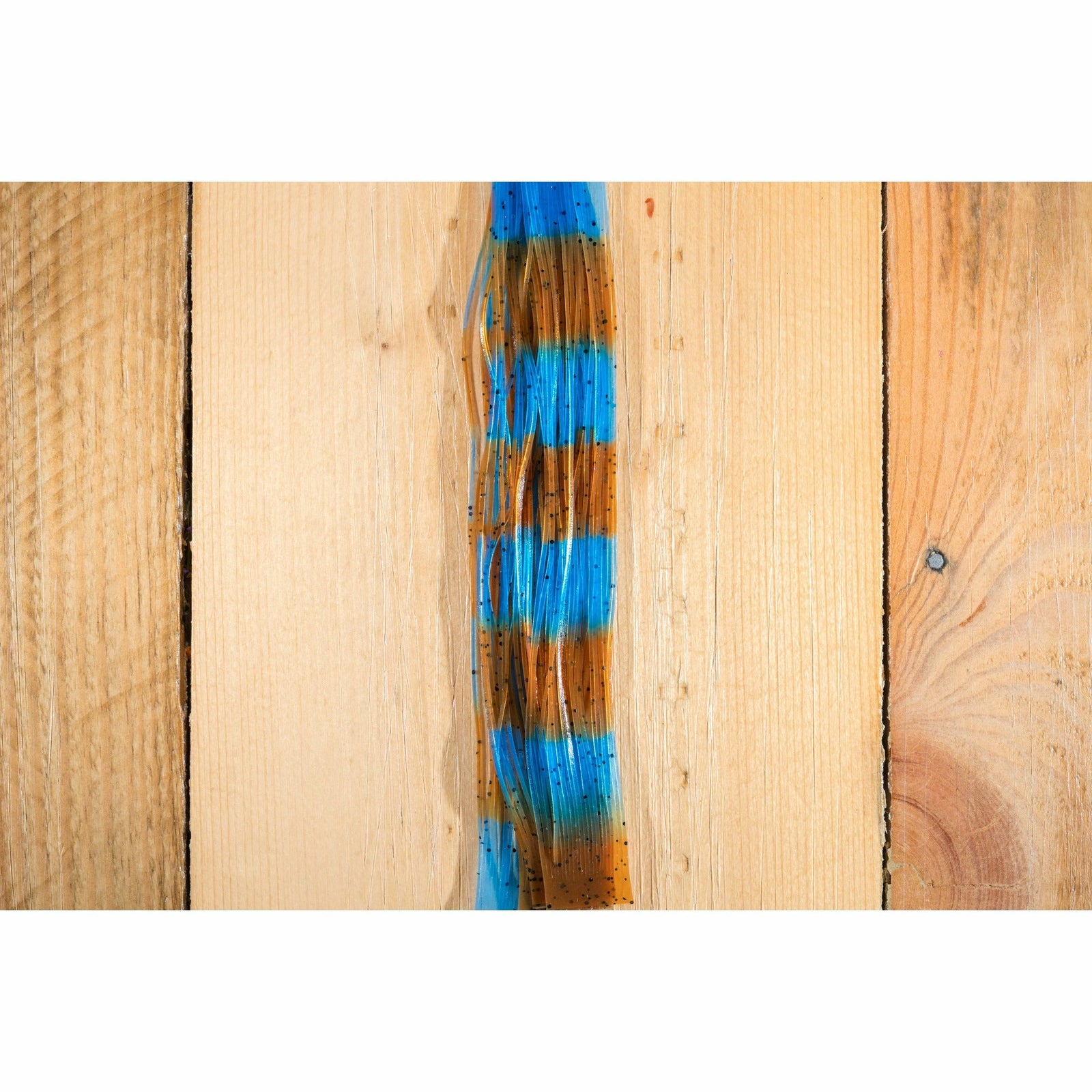 Close-up of synthetic fly tying legs showing blue and orange color bands
