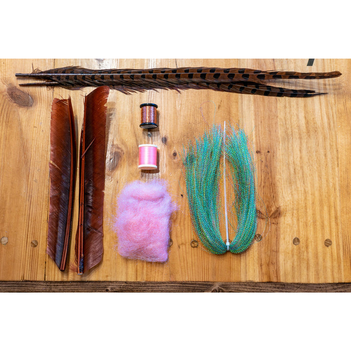 Fly tying kit contents including pheasant feathers, copper wire, and pink dubbing