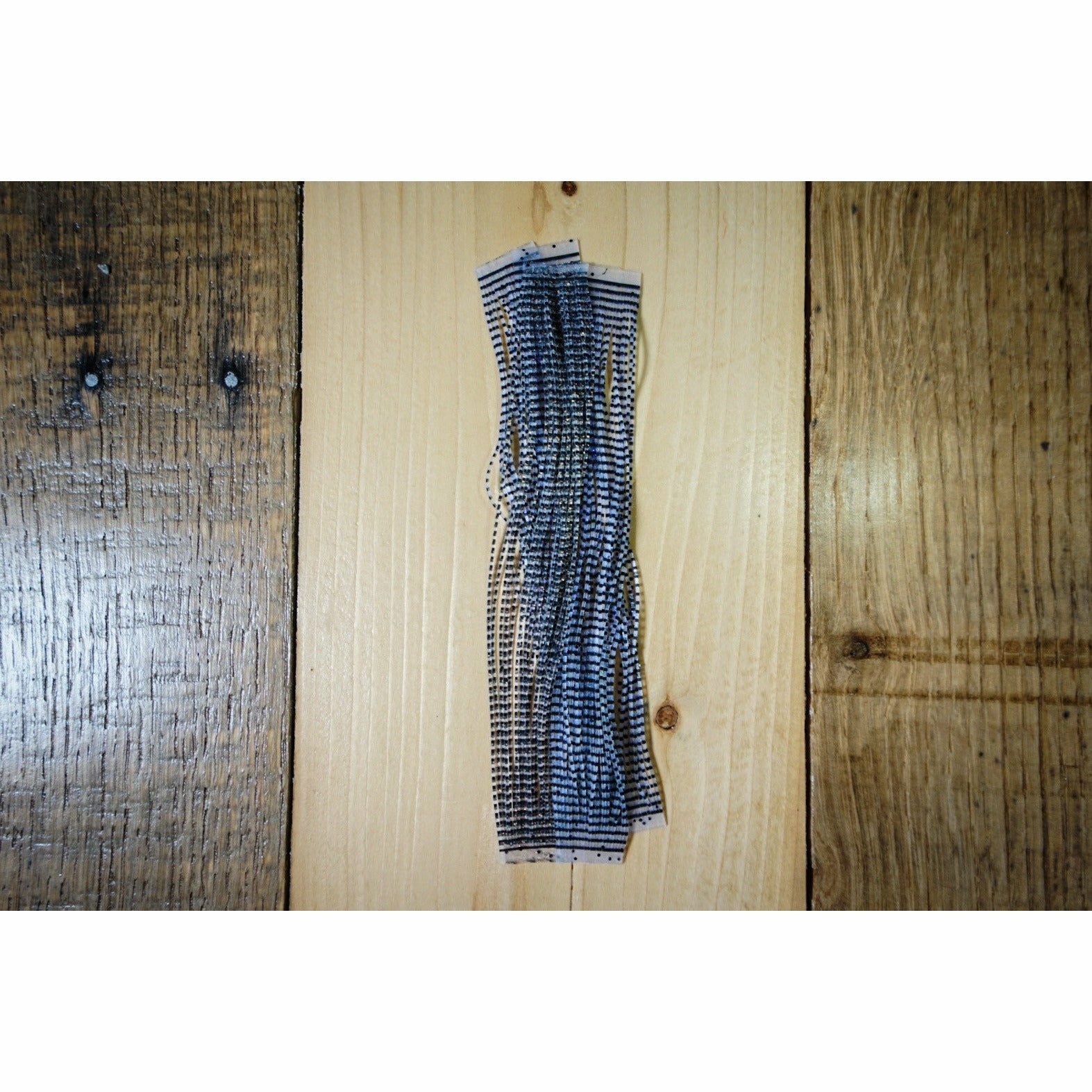Black barred Grizzly Flutter legs with clear UV reactive finish for fly tying