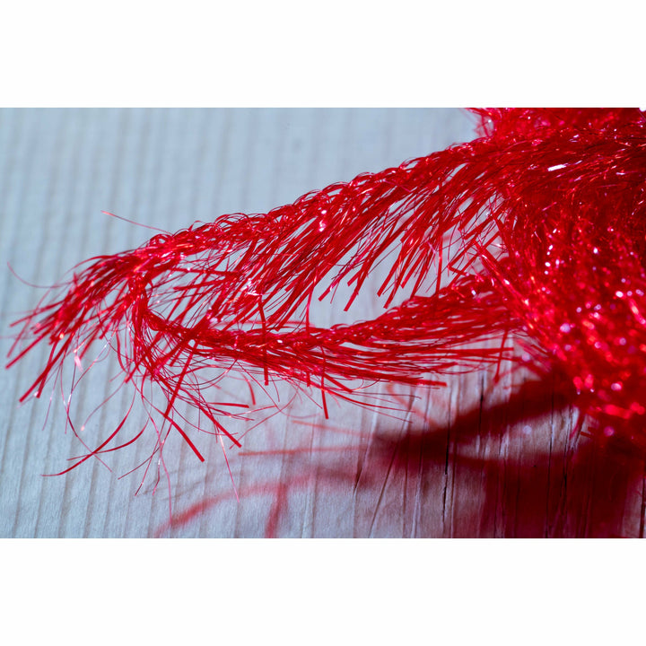 Close-up of translucent red synthetic hackle fibers and glittering flash strands