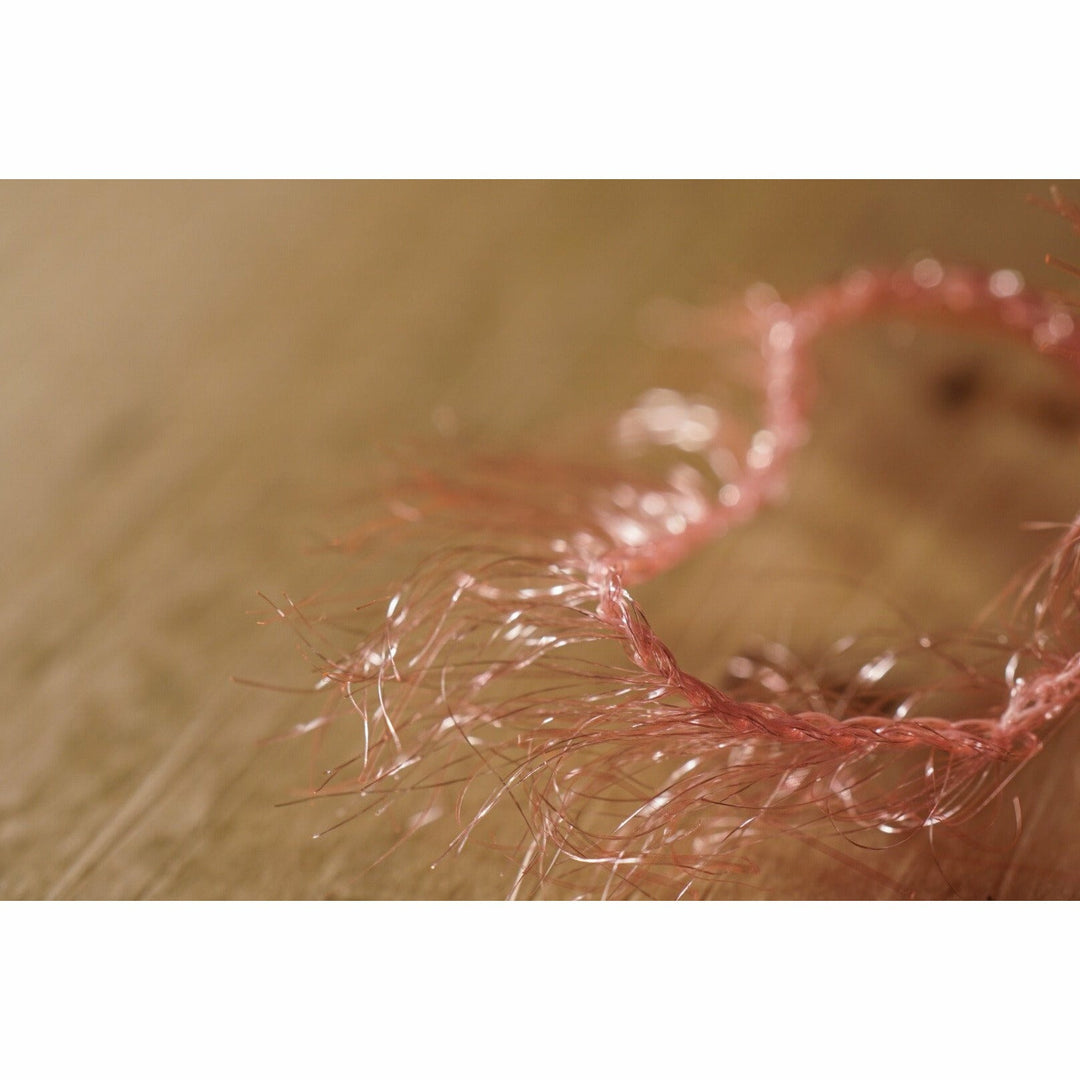Close-up of Shrimp Pink Krystal Hackle chenille with glossy synthetic fibers