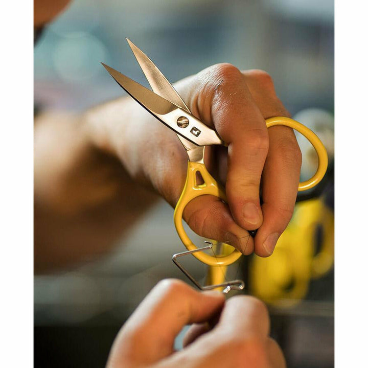 Yellow handled ergonomic scissors open for precision thread cutting