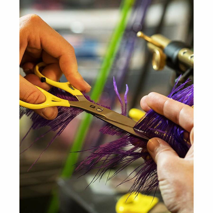 Ergonomic fly tying scissors slicing purple fibers