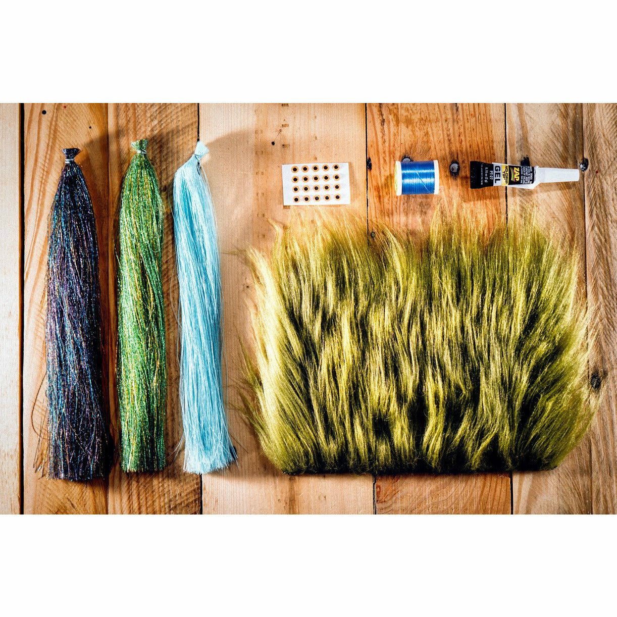 Bluegill Light Saber DIY fly tying kit materials including thread, eyes, and fibers