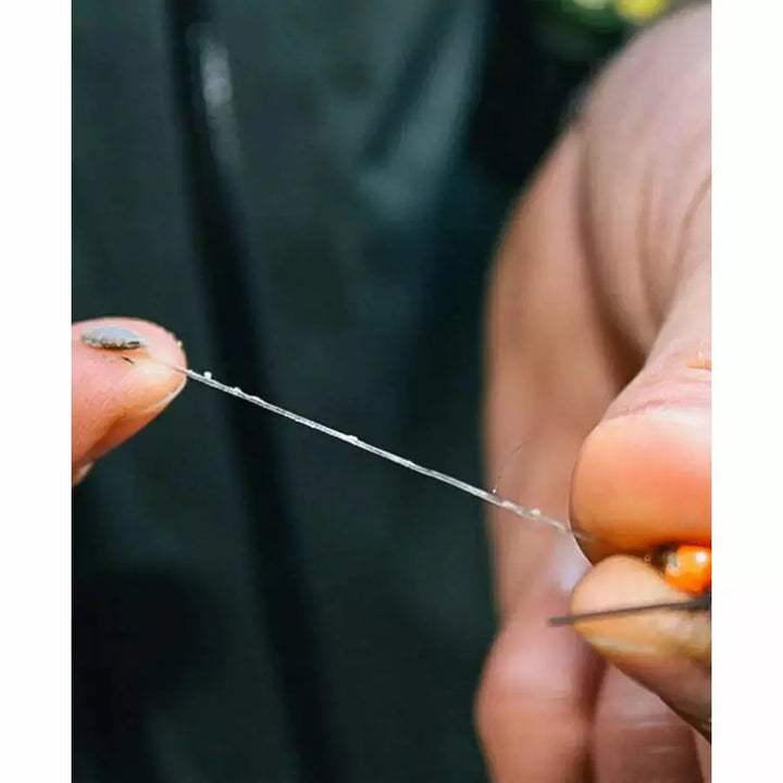 Fishing leader coated with Loon Snake River Mud sink paste on orange bead fly