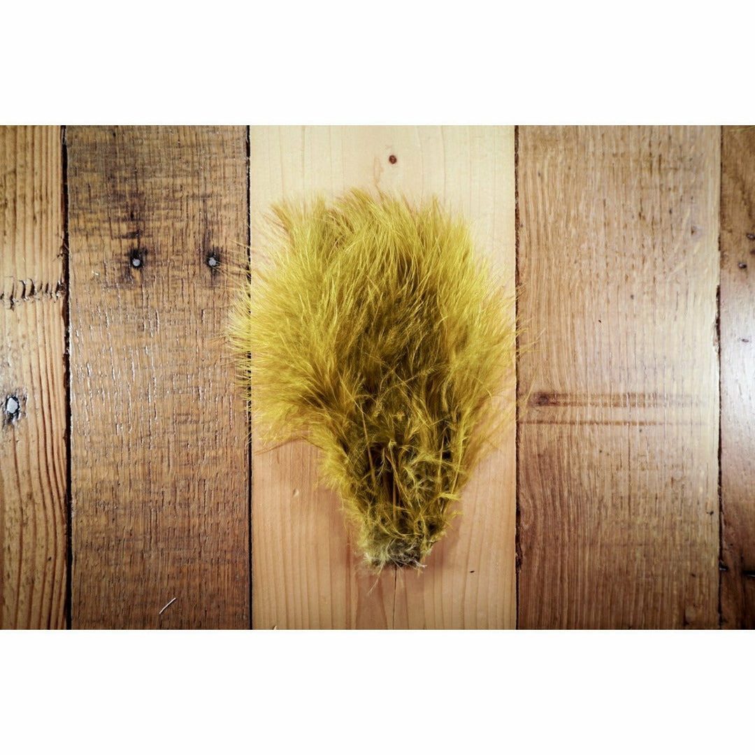 Mustard Marabou feathers fanned on wood surface