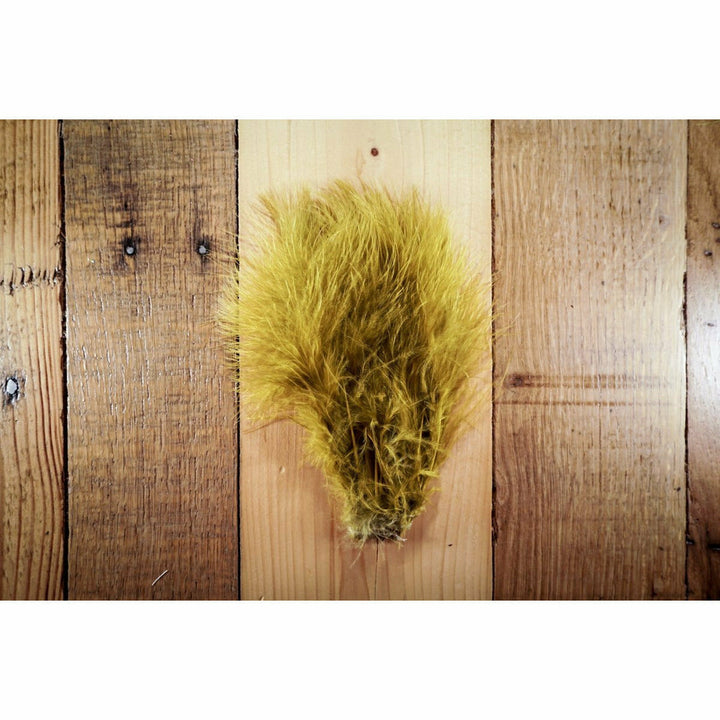 Mustard Marabou feathers fanned on wood surface