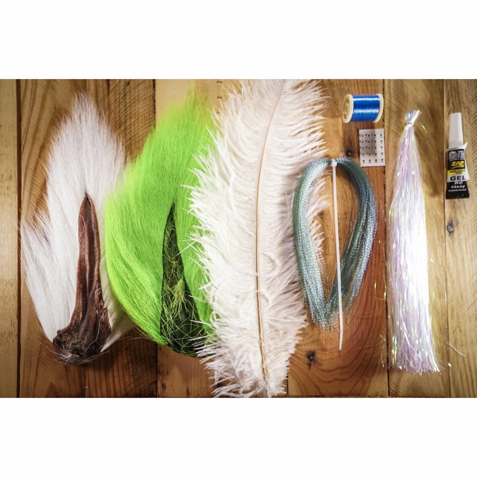 NDCver DIY Threadfin fly tying kit materials including white bucktail, lime ostrich plumes, flashabou, blue thread, and zap gel on wood